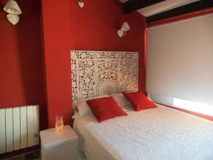 1 dormitorio con paredes rojas y 1 cama con almohadas rojas en Casa Rural Media Luna, en Segorbe