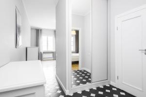 um quarto branco com um espelho e um piso preto e branco em Warsaw Old Town Apartments by Renters em Varsóvia