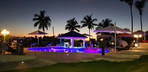 a swimming pool with purple lights at night at casaenjoysamana in Los Naranjos