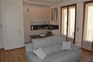 a living room with a couch and a kitchen at Vittori Apartment in Siena