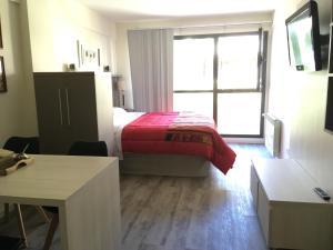 1 dormitorio con cama y ventana grande en Baritur en San Carlos de Bariloche