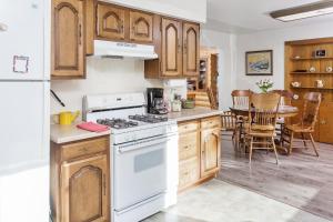a kitchen with wooden cabinets and a white stove top oven at Seward's Guest House in Seward