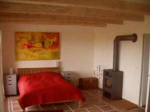 ein Schlafzimmer mit einem roten Bett und einem Gemälde an der Wand in der Unterkunft Hofboddenblick in Kückenshagen