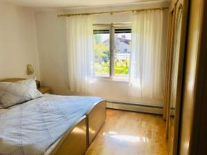 1 dormitorio con cama y ventana en Neurauter‘s FerienAppart: en Telfs