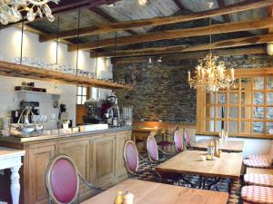 a kitchen with wooden tables and chairs in a room at Authentic Holiday Home located in Bievre with Jacuzzi in Bièvre