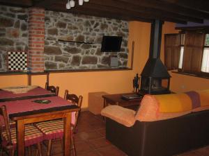 a living room with a table and a stove at La Portiella in Bueres