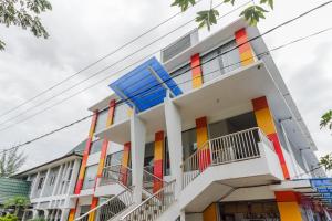 a building with colorful windows and balconies at RedDoorz Syariah near RSU Suaka Insan Banjarmasin in Banjarmasin
