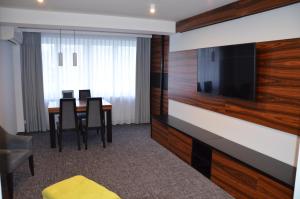 een kamer met een eettafel met stoelen en een flatscreen-tv bij Hotel Sport in Bełchatów