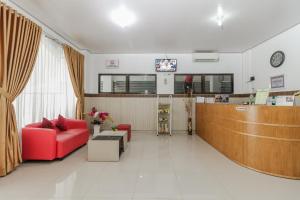 a waiting room with a red couch and aemedasteryasteryasteryasteryasteryastery at RedDoorz Syariah near RSU Suaka Insan Banjarmasin in Banjarmasin