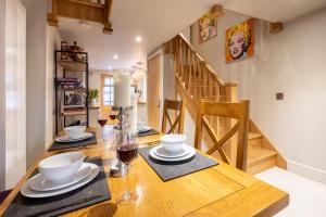 une salle à manger avec une table en bois et un escalier dans l'établissement Church Farm Lodge, à Aldeburgh