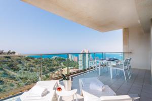 un balcon avec une table et des chaises et une vue sur l'océan dans l'établissement Apartamento Benidorm de Luxe, à Benidorm