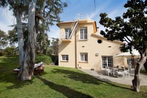 una casa grande con un árbol en el patio en Villa Gaudi en San Justo Desvern