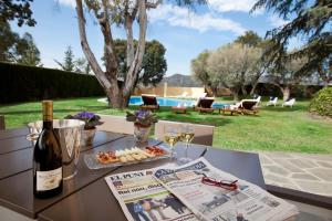 una mesa con una botella de vino y un plato de comida en Villa Gaudi en San Justo Desvern