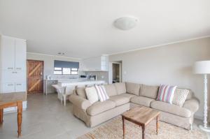 a living room with a couch and a kitchen at Herolds Bay Accommodation - Hiers Ons Weer Downstairs in Herolds Bay