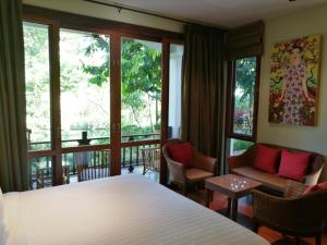 a bedroom with a bed and a balcony at Villa Albizia in Chiang Mai in Doi Saket