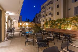 an outdoor patio with tables and chairs at night at Nemea Appart Hotel Cannes Palais in Cannes