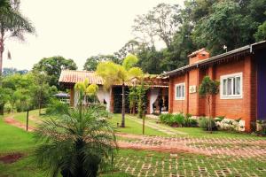 uma casa com uma palmeira em frente em Pousada Santa Thereza em Serra Negra