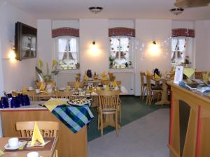 a restaurant with wooden tables and chairs and windows at Pension Granitzeck in Ostseebad Sellin