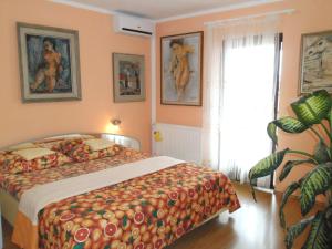 1 dormitorio con 1 cama y pinturas en la pared en Apartments Kestenovi Dvori, en Opatija