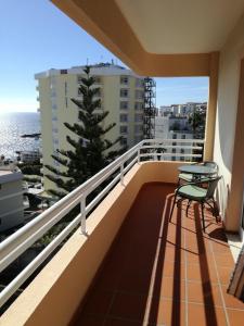 a balcony with a table and chairs and the ocean at Lido Funchal Apartment balcony sea view in Funchal
