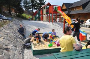 eine Gruppe von Kindern, die in einem Sandkasten auf einem Spielplatz spielen in der Unterkunft Drevenica Viki in Terchová