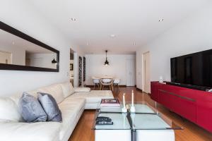 sala de estar con sofá blanco y TV en InkaHuset Miraflores Deluxe, en Lima