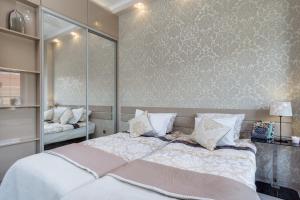 グダニスクにあるElite Apartments Tartaczna Deluxeのベッドルーム(白い枕の大型ベッド1台付)