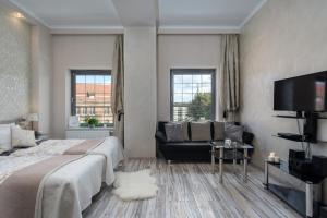 - une chambre avec un lit, une télévision et un canapé dans l'établissement Elite Apartments Tartaczna Deluxe, à Gdańsk