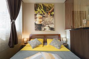 sypialnia z łóżkiem z żółtą pościelą i poduszkami w obiekcie La Kazette - Votre Studio de Vacances à l Île de La Réunion w mieście Saint-Louis
