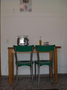 a table with two green chairs next to a table at The Ideal House In The City Center in Veria