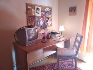 a room with a desk with a tv and a chair at The Ideal House In The City Center in Veria