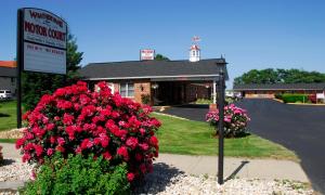 a sign in front of a store with red flowers at Weathervane Motor Court in Ronks