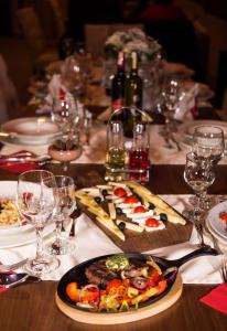 une table avec des assiettes de nourriture et des verres à vin dans l'établissement Motel Saraj, à Gornji Vakuf