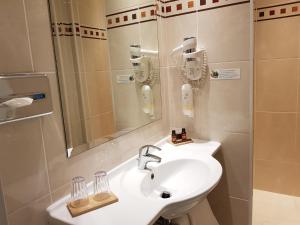 a bathroom with a sink and a mirror at Hotel Champerret Elysees in Paris