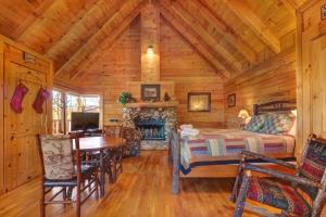 a bedroom with a bed and a fireplace in a log cabin at Majestic View #42B in Sevierville