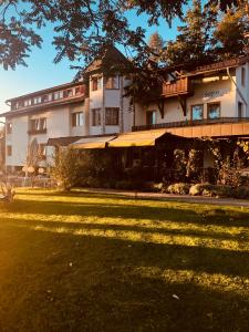 a large building with a lawn in front of it at Hotel - Restaurant Soleo in Krumpendorf am Wörthersee