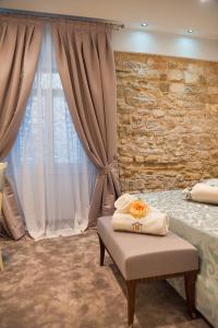 a bedroom with a bed and a stone wall at Heritage Hotel Antique Split in Split