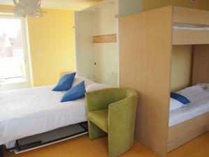 a bedroom with a bunk bed with a green chair at Hôtel Le Vivier WISSANT - Centre Village - Côte d'Opale - Baie de Wissant - 2CAPS in Wissant