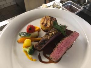 un plato de comida con carne y verduras en una mesa en Landgasthaus Bären en Grub