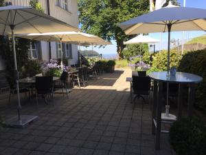 eine Terrasse mit Tischen, Stühlen und Sonnenschirmen in der Unterkunft Landgasthaus Bären in Grub