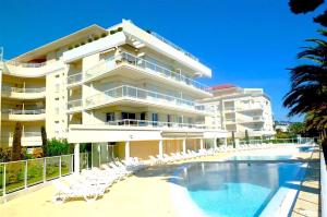 a large building with a swimming pool and chairs at L'appartement Royal Palm in Cannes