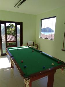 un tavolo da biliardo in un soggiorno con piscina di Paraíso de Toque Toque Grande a São Sebastião