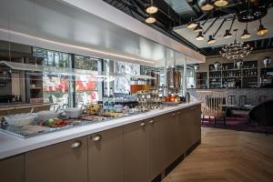 a restaurant with a counter with food on it at ibis Styles Genève Carouge in Geneva