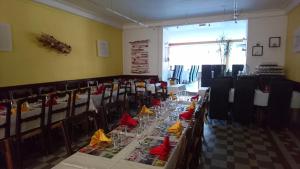 una sala da pranzo con tavoli lunghi e sedie con tovaglioli di Hotel Des Négociants a Lamastre