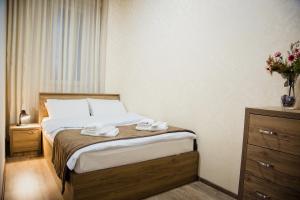 1 dormitorio con 1 cama con 2 toallas en TB Apart-Hotel in Tbilisi 1 en Tiflis