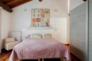 1 dormitorio con 1 cama rosa y 1 silla en Appartamento San Michele, en Milán