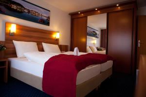 ウールディンゲン・ミュールホーフェンにあるHotel Knaus am Hafenのベッドルーム1室(赤毛布付きの大型ベッド1台付)