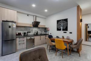 kuchnia ze stołem i krzesłami oraz kuchnia z lodówką w obiekcie krtsanisi twins luxury apartment w mieście Tbilisi City