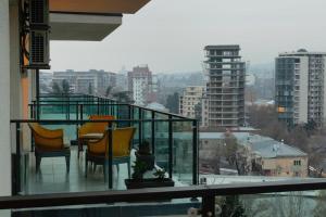 balkon z krzesłami i widokiem na miasto w obiekcie krtsanisi twins luxury apartment w mieście Tbilisi City