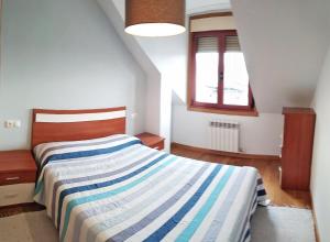 1 dormitorio con 1 cama con manta a rayas en Vistas de lujo e inmejorable ubicación en Combarro, en Combarro